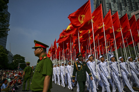 Para peserta yang memegang bendera komunis berbaris dalam parade yang menandai peringatan 50 tahun jatuhnya Saigon dan berakhirnya Perang Vietnam di Ho Chi Minh City... </div>
<div class=