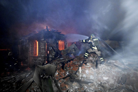 Seorang petugas penyelamat Ukraina berupaya memadamkan api di lokasi serangan pesawat tak berawak di Kharkiv, Ukraina, Selasa (29/4/2025). Foto: Sergey Bobok/AFP