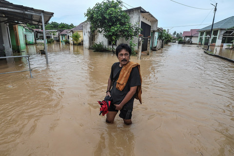 Warga berjalan di kawasan perumahan yang terendam banjir di Kenali Asam Bawah, Jambi, Rabu (30/4/2025). Foto: Wahdi Septiawan/ANTARA FOTO