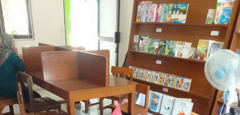 Meja dan kursi kayu di bagian deoan ruang perpustakaan. (Foto: Mohamad Jokomono)