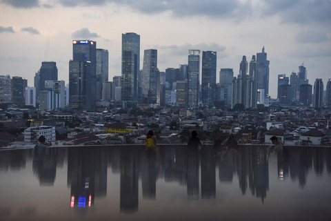 Warga berfoto dengan latar belakang gedung bertingkat di Jakarta, Rabu (30/4/2025). Foto: Indrianto Eko Suwarso/ANTARA FOTO