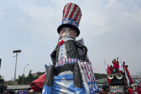Sejumlah massa dari elemen buruh membawa patung Paman Sam berwajah Donald Trump saat mengikuti aksi May Day 2025 di depan Kompleks Parlemen, Senayan, Jakarta, Kamis (1/5/2025). Foto: Abid Raihan/kumparan