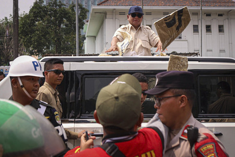 Presiden Republik Indonesia Prabowo Subianto membagikan kaos dari Mobil Maung saat meninggalkan perayaan May Day di kawasan Monas, Jakarta, Kamis (1/5/2025). Foto: Iqbal Firdaus/kumparan
