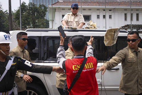 Presiden Republik Indonesia Prabowo Subianto membagikan kaos dari Mobil Maung saat meninggalkan perayaan May Day di kawasan Monas, Jakarta, Kamis (1/5/2025). Foto: Iqbal Firdaus/kumparan