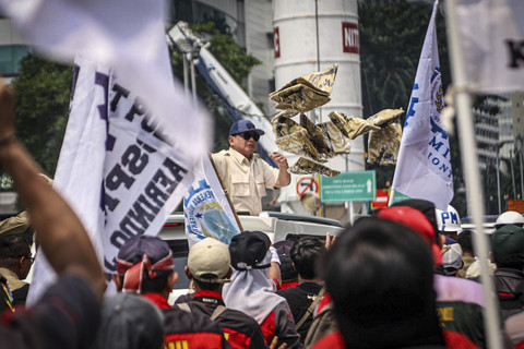 Presiden Republik Indonesia Prabowo Subianto membagikan kaos dari Mobil Maung saat meninggalkan perayaan May Day di kawasan Monas, Jakarta, Kamis (1/5/2025). Foto: Iqbal Firdaus/kumparan