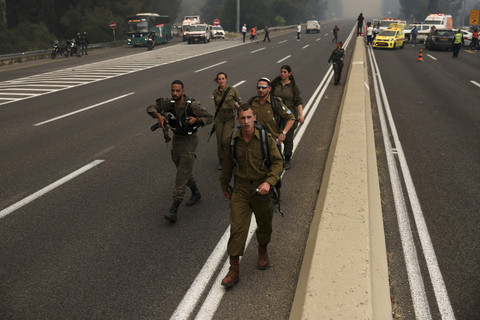 Sejumlah tentara Israel berjaga saat kebakaran hutan di kawasan Bet Shemesh, Israel, Kamis (30/4/2025). Foto: Ahmad Gharabli/AFP