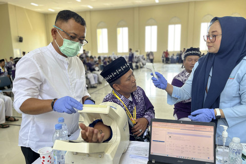 Petugas memeriksa kesehatan jamaah calon haji asal Jawa Barat kelompok terbang (kloter) pertama di Embarkasi Kertajati, Kabupaten Indramayu, Jawa Barat, Kamis (1/5/2025). Foto: kumparan