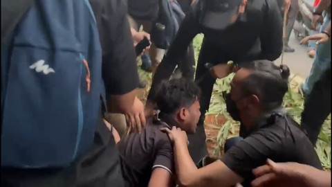 Seorang pria terluka saat pembubaran aksi massa May Day di Gedung DPR. Foto: Abid Raihan/kumparan