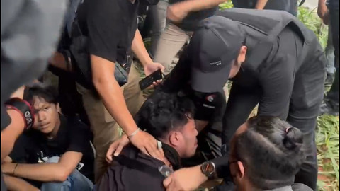 Seorang pria terluka saat pembubaran aksi massa May Day di Gedung DPR. Foto: Abid Raihan/kumparan