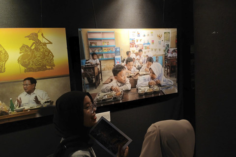 Pengunjung mengamati karya foto pada pameran foto 'Sing Penting Madhang' di Gallery Gelanggang Inovasi dan Kreativitas (GIK) Universitas Gadjah Mada (UGM), Kamis (1/5/2025) malam. Foto: Arfiansyah Panji Purnandaru/kumparan