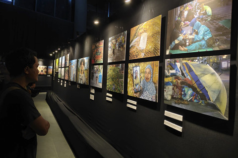 Pengunjung mengamati karya foto pada pameran foto 'Sing Penting Madhang' di Gallery Gelanggang Inovasi dan Kreativitas (GIK) Universitas Gadjah Mada (UGM), Kamis (1/5/2025) malam. Foto: Arfiansyah Panji Purnandaru/kumparan