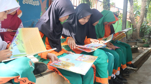 Siswa-siswi saat membaca buku dari Mobil Pintar PT Bukit Asam. Foto: Dok. PT Bukit Asam