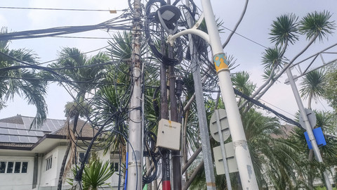 Pemandangan kabel semrawut dan menjuntai di sekitran Kantor Kementerian Agama Jakarta Pusat yang ada kawasan Jalan Perwira sekitar Masjid Istiqlal, Jumat (2/5/2025).  Foto: Thomas Bosco/kumparan