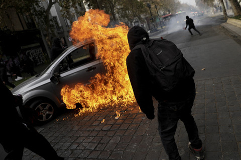 Pengunjuk rasa membakar mobil saat aksi May Day 2025 di Santiago, Chile, Kamis (1/5/2025). Foto: Juan Gonzalez/Reuters