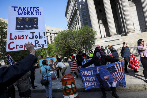 Sejumlah pengunjuk rasa membentangkan poster saat May Day 2025 di New York, Amerika Serikat, Kamis (1/5/2025). Foto: Jeenah Moon/REUTERS