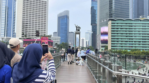 Warga antre untuk berfoto di halte Transjakarta Bundaran Hotel Indonesia, Jakarta, Minggu (4/5/2025). Foto: Haya Syahira/kumparan