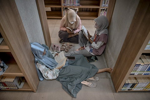 Pengunjung tampak membaca buku di Perpustakaan Jakarta yang berada di Kompleks Taman Ismail Marzuki (TIM), Jakarta, pada Minggu (4/5/2025). Foto: Jamal Ramadhan/kumparan