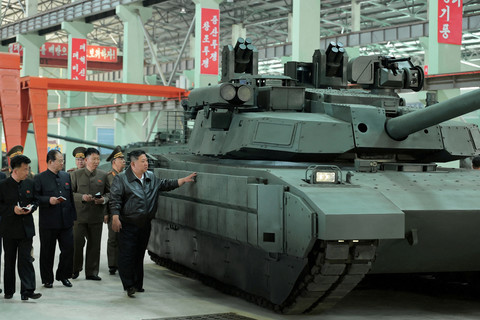 Pemimpin Korea Utara Kim Jong-un melihat tank lapis baja di fasilitas peralatan militer yang tidak ditentukan lokasinya di Korea Utara. Foto: KCNA/via REUTERS