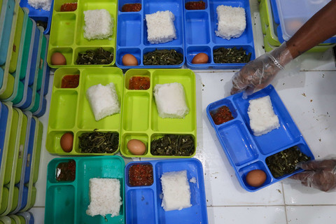 Warga binaan yang bertugas di dapur menyajikan nasi cadong untuk warga binaan lainya di dalam Lapas kelas IIA Banyuwangi, Jawa Timur. Foto: Budi Candra Setya/ANTARA FOTO