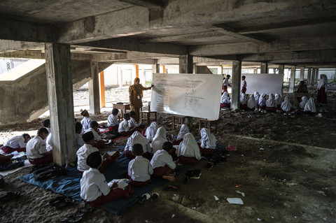 Sejumlah siswa kelas 3 dan 6 mengikuti kegiatan belajar mengajar di kolong bangunan SD Negeri Bendono 1, Sayung, Kabupaten Demak, Jawa Tengah, Senin (5/5/2025). Foto: Aprillio Akbar/ANTARA FOTO