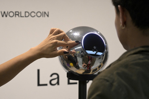 Seorang pria menjalani pemindaian iris mata dengan bola mata, perangkat pemindai data biometrik, untuk ditukar dengan mata uang kripto Worldcoin di Buenos Aires (22/3/2024). Foto: Juan Mabromata/AFP