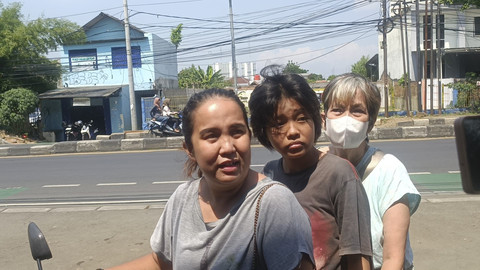 Leona (34), warga Bekasi Timur yang datang ke Ruko Worldcoin di Jalan Insiyur H Juanda, yang telah tutup membonceng anak dan ibunya, Senin (5/5/2025). Foto: Thomas Bosco/kumparan