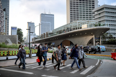 Pekerja melintasi pelican crossing saat jam pulang kerja di Kawasan Jalan Jendral Sudirman, Jakarta, Senin (5/5/2025). Foto: Jamal Ramadhan/kumparan