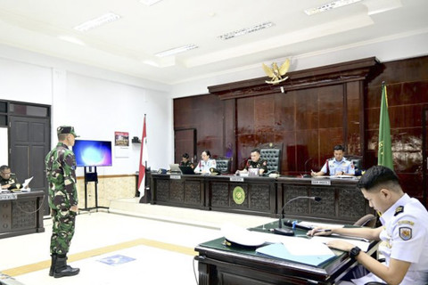 Terdakwa Kelasi Satu Jumran (berdiri kedua kiri) mendengarkan pembacaan surat dakwaan oleh Kepala Odmil III-15 Banjarmasin Letkol CHK Sunandi di hadapan majelis hakim dalam sidang kasus pembunuhan jurnalis Juwita di Pengadilan Militer (Dilmil). Foto: Tumpal Andani Aritonang/Antara