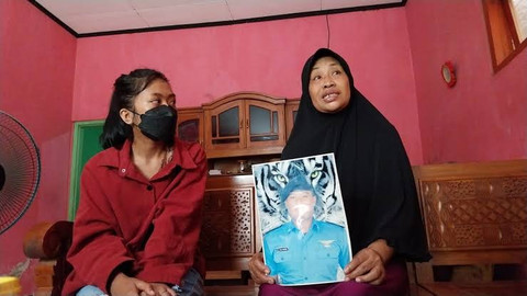 Keluarga dari Pekerja Migran Indonesia (PMI) asal Banyuwang menunjukkan foto Rizal Sampurna yang tewas di Kamboja, Rabu (7/5). Foto: Dok. kumparan