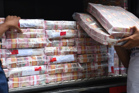 Petugas membawa barang bukti uang hasil sitaan pada perkara TPPU perjudian daring saat gelar perkara di Gedung Bareskrim Polri, Jakarta, Rabu (7/5/2025). Foto: Indrianto Eko Suwarso/ANTARA FOTO