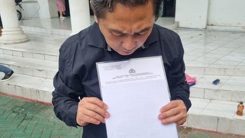 Tanu Hariadi menunjukkan surat pelaporan di Polrestabes Surabaya, Rabu (7/5/2025). Foto: Farusma Okta Verdian/kumparan