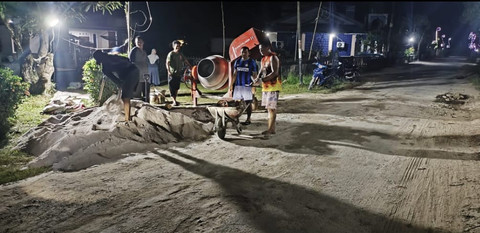 Warga Desa Antibar gotong royong perbaiki jalan rusak pada malam hari. Foto: M. Zain/Hi!Pontianak