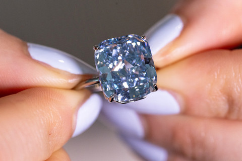 Staf Sotheby memegang "The Mediterranean Blue", berlian biru cemerlang seberat 10,03 karat selama pratinjau lelang di Jenewa, Swiss, Kamis (8/5/2025). Foto: Denis Balibouse/REUTERS