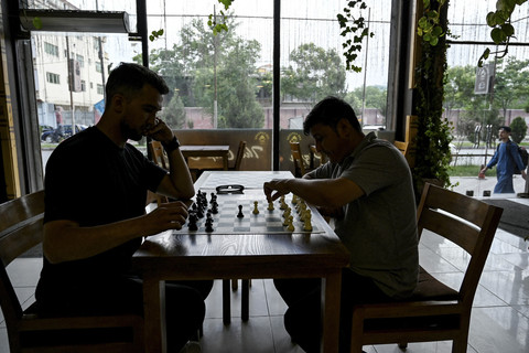 Dua pria memainkan catur di kafe Cupcake Coffee Shop, Kabul, Afganistan, Minggu (11/5/2025).   Foto: Wakil Kohsar/AFP