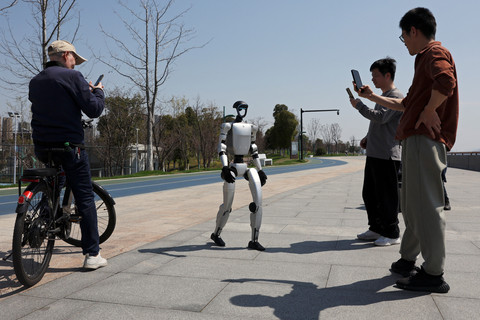 Robot humanoid berjalan saat karyawan melakukan pengujian pada robot, di jalur produksi di pabrik AgiBot di Shanghai, Tiongkok, 20 Maret 2025.  Foto: REUTERS/Florence Lo