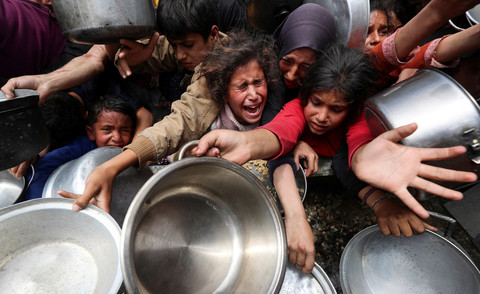Warga Palestina menunggu untuk menerima makanan yang dimasak oleh dapur amal, di Jabalia, di Jalur Gaza utara, 14 Mei 2025. Foto: REUTERS/Mahmoud Issa