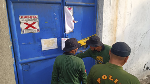 Kepolisian dari Polda Jatim dan Satpol PP Surabaya mencoba membuka gudang perusahaan Sentoso Seal di kawasan Margomulyo, Surabaya, Kamis (15/5/2025). Foto: Farusma Okta Verdian/kumparan