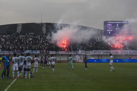 Pendukung menyalakan suar saat pertandingan antara Persita Tangerang melawan Persib Bandung pada pertandingan BRI Liga 1 2024/2025 di Stadion Indomilk Arena, Kabupaten Tangerang, Banten, Jumat (16/5). Foto: ANTARA FOTO/Galih Pradipta
