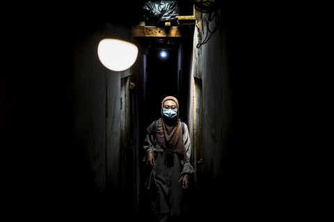 Melintasi Lorong Pemukiman Padat Penduduk: Perawat paliatif Tyas melintasi lorong permukiman padat penduduk usai memeriksa pasiennya di Jakarta. Foto: Rivan Awal Lingga/ANTARA FOTO