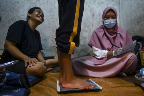 Memeriksa Pasien: Perawat paliatif Mutiara (kanan) memeriksa pasiennya di Jakarta. Foto: Rivan Awal Lingga/ANTARA FOTO