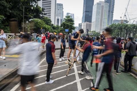 Warga mencoba permainan tradisional Egrang yang diadakan relawan penggerak olahraga DKI Jakarta saat Hari Bebas Kendaraan Bermotor (HBKB) atau Car Free Day (CFD) di Jalan Jenderal Sudirman, Jakarta, Minggu (18/5/2025). Foto: Bayu Pratama S/ANTARA FOTO