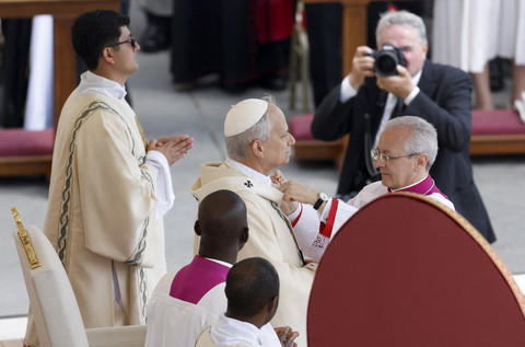 Paus Leo XIV menyesuaikan pallium saat misa inaugurasinya di Vatikan, Minggu (18/5/2025). Foto: Remo Casilli/REUTERS