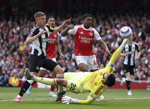 Kiper Arsenal David Raya berusaha menepis tendangan pemain Newcastle United Harvey Barnes pada pertandingan Liga Inggris di Stadion Emirates, London, Inggris, Minggu (18/5/2025). Foto: John Sibley/Reuters