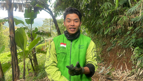 Pengemudi ojek online, Hasan Fiidel, menambal jalan rusak di Kabupaten Bandung. Foto: kumparan