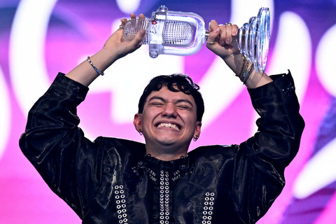 Penyanyi Austria Johannes Pietsch alias JJ merayakan kemenangannya dengan trofi Kontes Lagu Eurovision 2025 setelah memenangkan final di arena St. Jakobshalle di Basel, Minggu (18/5/2025). Foto: Fabrice COFFRINI / AFP