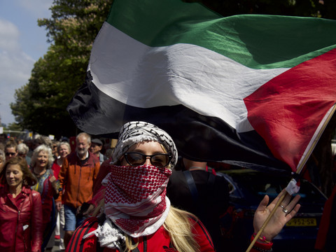 Seorang demonstran memegang bendera Palestina selama protes menekan pemerintah Belanda agar mengakhiri operasi Israel di Gaza di Den Haag, Belanda pada Minggu, 18 Mei 2025. Foto: Niels van der Pas via AP