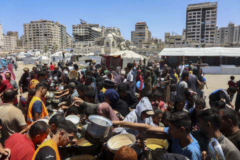 Warga Palestina mengantre untuk menerima makanan hangat di titik distribusi makanan di lingkungan Al-Rimal di Kota Gaza di Jalur Gaza bagian tengah, Rabu (21/5/2025). Foto: OMAR AL-QATTAA/AFP
