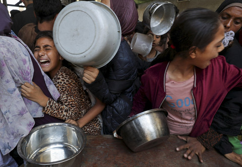 Warga Palestina menunggu untuk menerima makanan yang dimasak oleh dapur amal, di Kota Gaza, Rabu (21/5/2025). Foto: Mahmoud Issa/REUTERS
