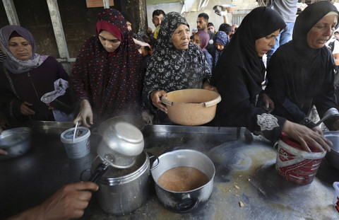 Warga Palestina menunggu untuk menerima makanan yang dimasak oleh dapur amal, di Kota Gaza, Rabu (21/5/2025). Foto: Mahmoud Issa/REUTERS