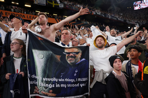 Suporter bawa poster Ange Postecoglou usai Tottenham Hotspur tekuk Manchester United (MU) dalam final Liga Europa 2024/25 di Stadion San Mames, Spanyol, Kamis (22/5) dini hari WIB. Foto: REUTERS/Isabel Infantes